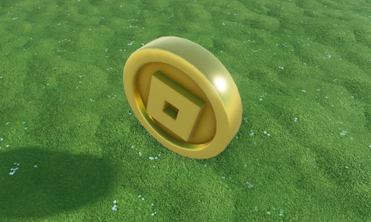 A close up view of a shiny gold coin with a Roblox icon in the middle. The coin floats over a grassy path of island.